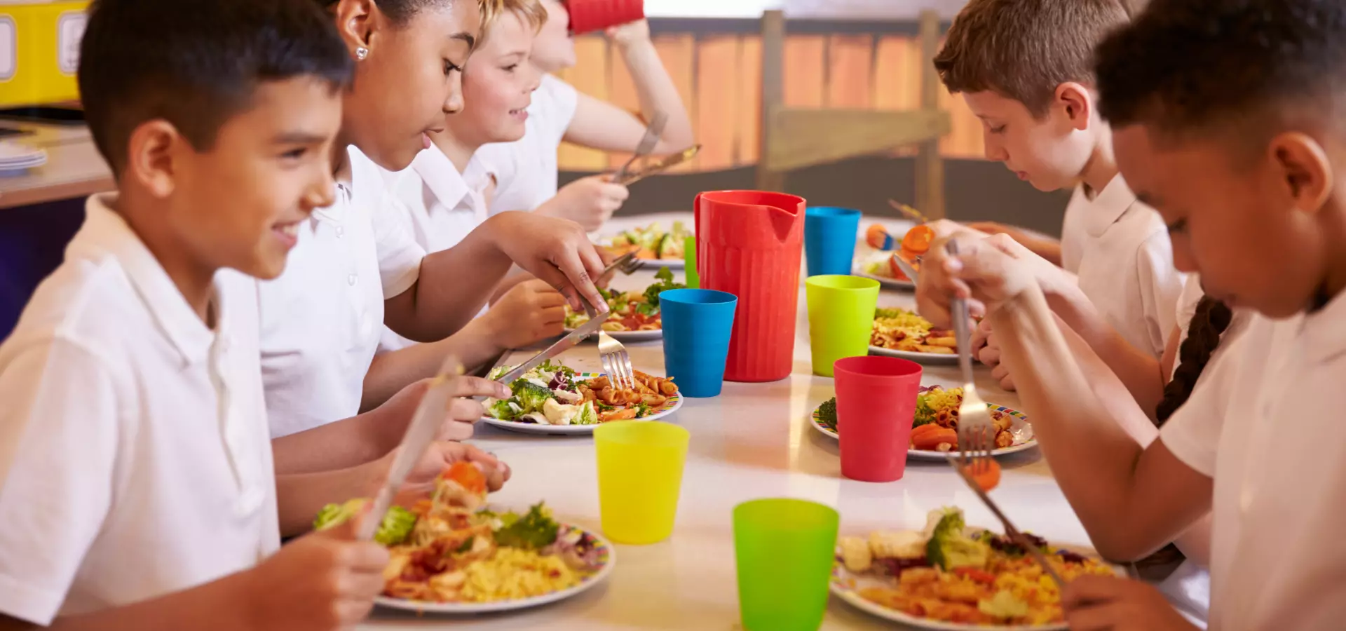 Children in school uniforms having lunch.