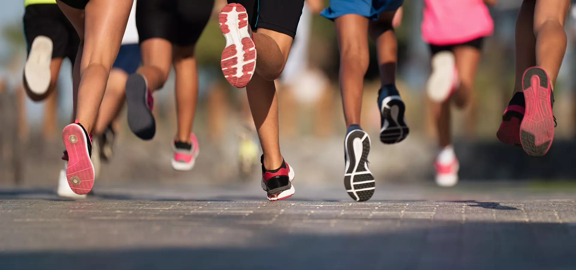 Legs of people running, wearing running attire.