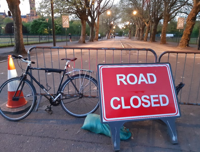 Photo of road barriers, a road closed sign and a bicycle.