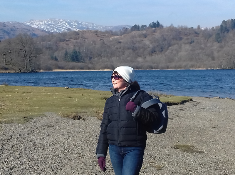 Carol standing in front of scenery including mountains and a loch